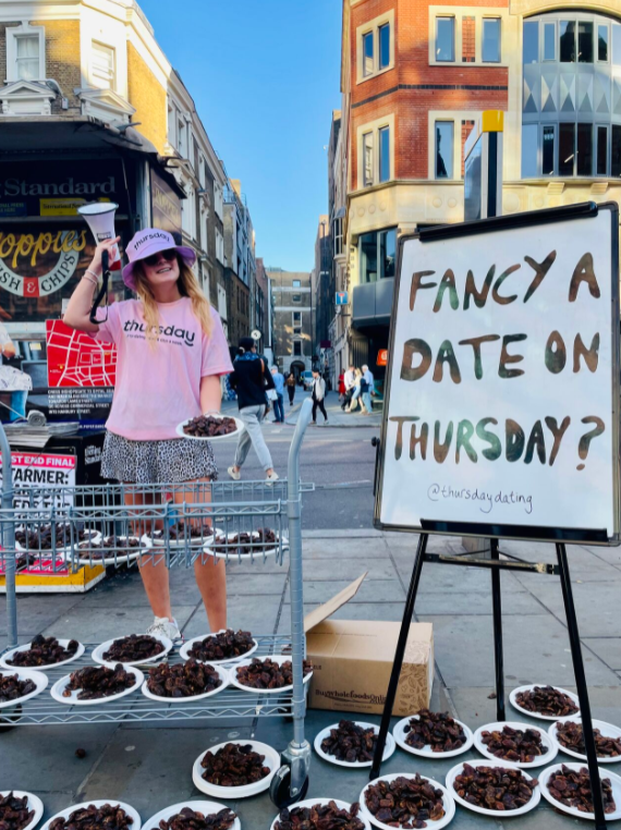 A photo of one of Thursday's outdoor marketing strategy. They're handing out Dates, the fruit, as a nod to Fancying a Date because they're a dating app.
